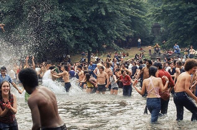 11. A crowd frolics in an unidentified lake in 1970.