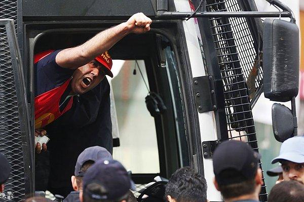 6. Gözaltına alınan bir gösterici polis aracından slogan atıyor