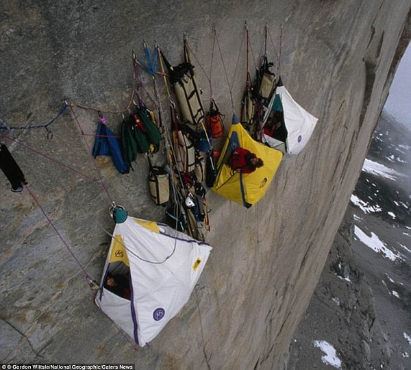16. Альпинисты отдыхают в палатках на отвесной скале на высоте 1200 метров.