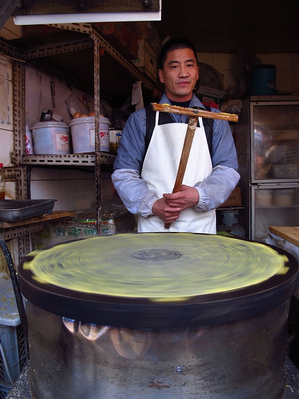1. Уличный торговец в Китае готовит фирменный китайский уличный завтрак - джиан бинг (яичный блин).
