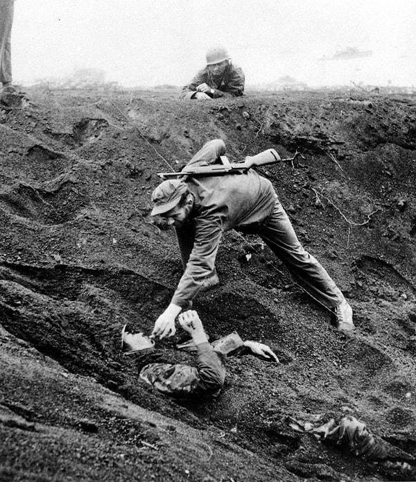 19. Kendini toprağa gömerek iki gün boyunca ölü taklidi yaptığı öğrenilen Japon askeriyle sigarasını paylaşan Amerikan askeri, Iwo Jima, Mart 1945.