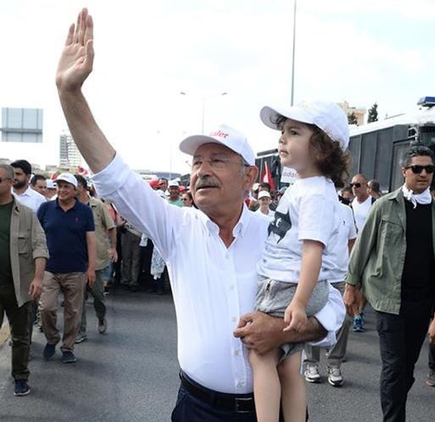 Bir çocuğu kucağına alarak yürüdü
