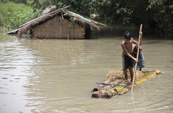 7. Hindistan'ın Assam bölgesinde iki erkek çocuk bir salla kaçmaya çalışıyor. Bölgede 850 kişi hayatını kaybetti.