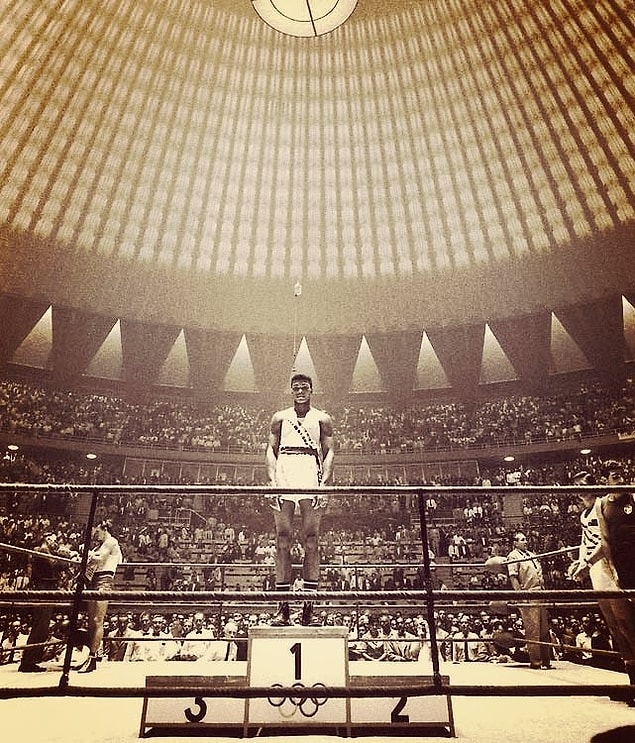 17. 18 yaşındaki Muhammad Ali tek başına 1.'lik kürsüsünde dikilirken, Roma Olimpiyatları, 1960.