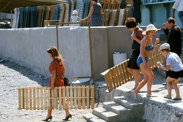 3. Отдыхающие берут шезлонги, чтобы устроиться поудобнее на галечном пляже 🏝