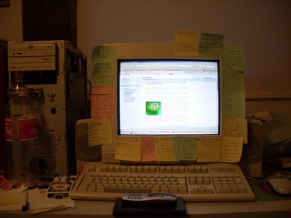14. Odasında duran üstü post-itlerle kaplanmış bir bilgisayar