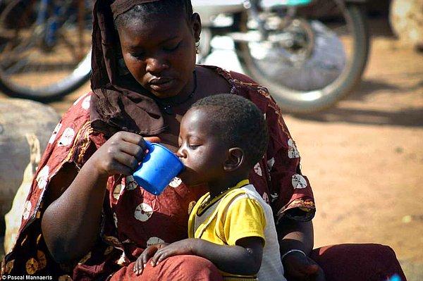 4. Bu fotoğrafta ise Mali, Batı Afrika'dan bir annenin çocuğuna dikkatlice su içirdiği görülüyor.
