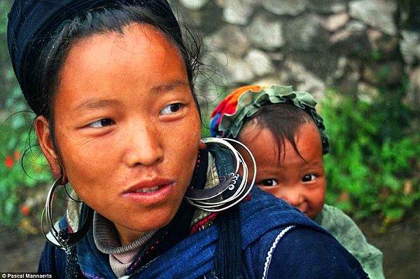 14. Sa Pa, Viyetnam'da bir çocuk annesinin sırtında yaramazca gülümsüyor.