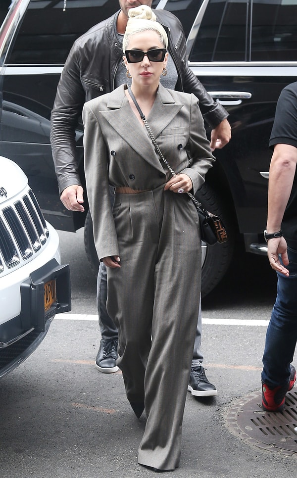 Смотрите сами! Следующее утро, и Гага в комбинезоне-пиджаке, волосы убраны в строгий пучок, минимум макияжа и аксессуаров!