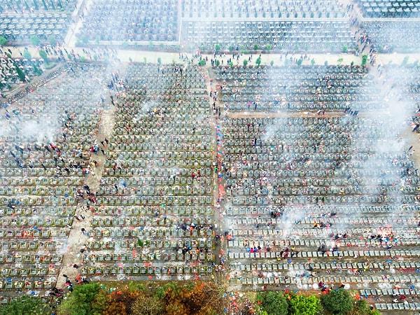 5. Fuzhou'da, Qingming ya da Mezar Süpürme Festivali sırasında halka açık bir mezarlıkta dua ederken kağıt para yakıyor insanlar.