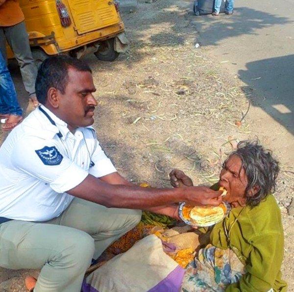1. Hindistan'da bir trafik polisi, yemek yiyemeyecek kadar yorgun düşmüş olan yaşlı kadının karnını doyuruyor.
