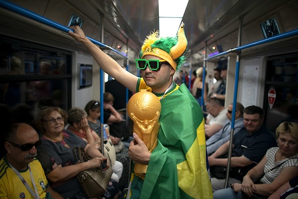 6. Обычный день в московском метро: футбольный фанат в мантии из бразильского флага едет на стадион "Спартак" на матч группы Е между Бразилией и Сербией 27 июня.
