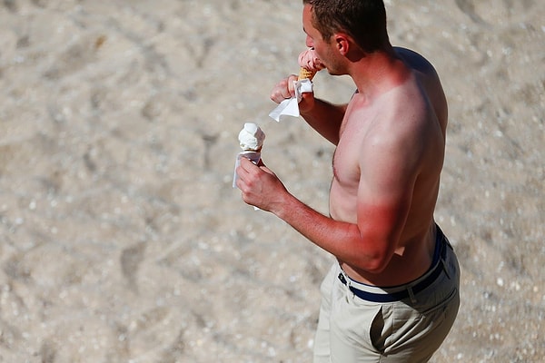 16. Мужчина с солнечными ожогами есть мороженое во французском городе Кабур 17 июня 2017 года.