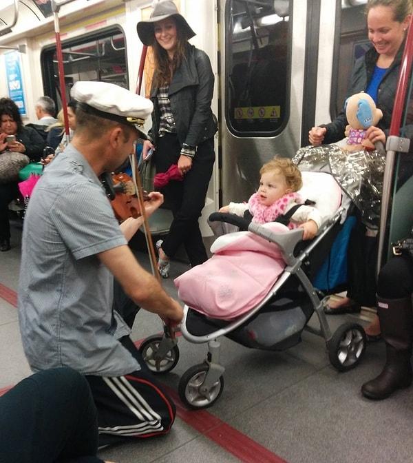 12. Metro yolculuğu boyunca ağlayan bebeğe keman çalan adam.
