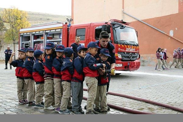 Kerim Türkmen kıyafetleri giydi, ardından itfaiye aracına binerek siren sesleri eşliğinde okuluna ulaştı.