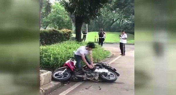 Kadın ağlarken erkek motosikleti parçaladı.
