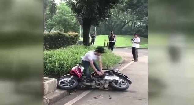 Kadın ağlarken erkek motosikleti parçaladı.