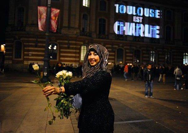 13. Paris'teki terör saldırılarının ardından Müslüman bir kız gül dağıtıyor.