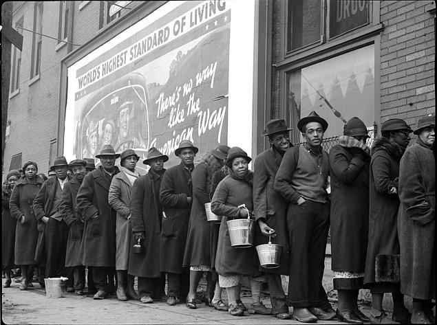 15. Siyahi sel kurbanları kıyafet ve yemek almak için Kızıl Haç istasyonunda sıraya giriyorlar, 2 Şubat 1937. Arkalarındaki afişte "Dünyanın en iyi yaşam standartları" yazması dikkat çekiyor.