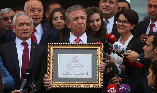 Ancak fotoğraf montajlanarak oluşturulmuş. Fotoğrafın orijinalinde Mansur Yavaş, 8 Nisan 2019’da Ankara Büyükşehir Belediyesi Başkanı olarak mazbatasını alıyor.