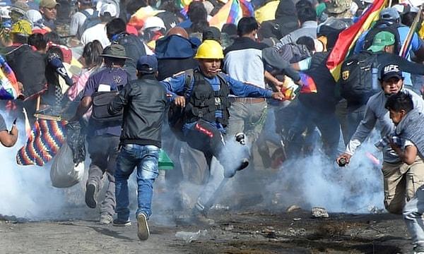Sacaba'daki koka yetiştiricileri ve eski başkan Evo Morales'in destekçileri, polisin attığı göz yaşartıcı gazlardan kaçıyor.