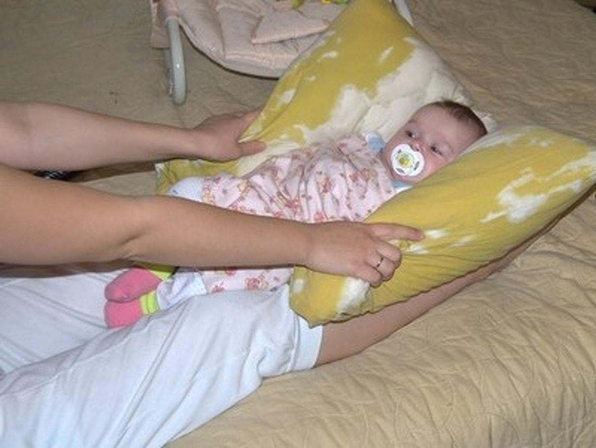 Подушка со скольки месяцев можно. Подушка для укачивания ребенка на ногах. Укачивание ребенка на ногах. Качание ребенка на ногах на подушке. Укачивание на подушке на ногах.