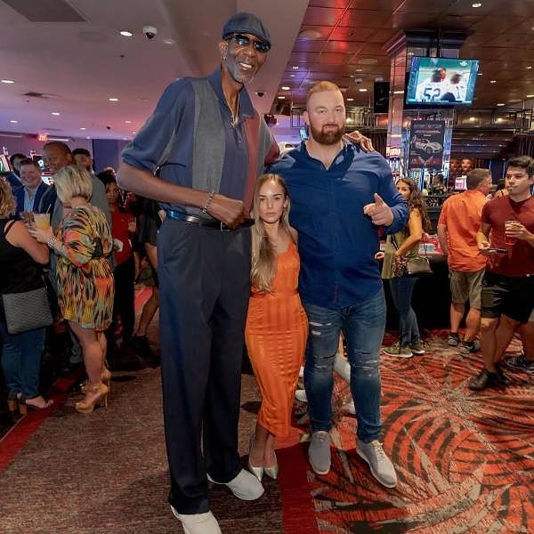 2. Атлет и актер Хафур Юлиус Бьёрнссон, его жена Келси Хенсон и баскетболист Джордж Белл