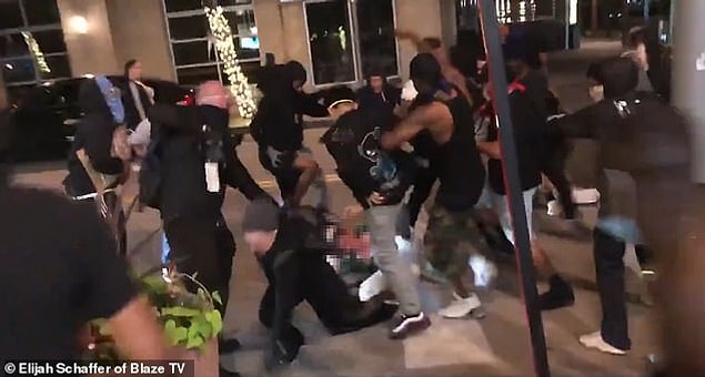 Bir protestocuyu kovalayan adam daha sonra ökfeli kalabalık tarafından acımasızca dövülüyor.