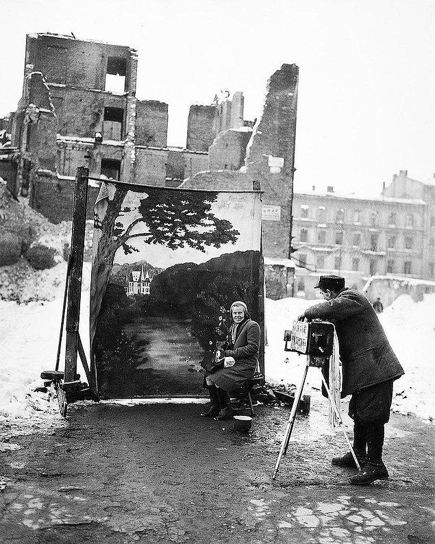 4. 2. Dünya Savaşından en çok etkilenen yer olan Varşova'da bir fotoğrafçı savaşın etkilerini gizlemek için arka fon kullanıyor.