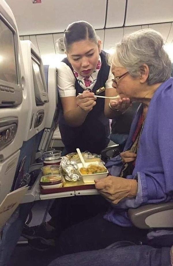 7. Yemek yerken zorlanan kadına yardımcı olan uçuş görevlisi...