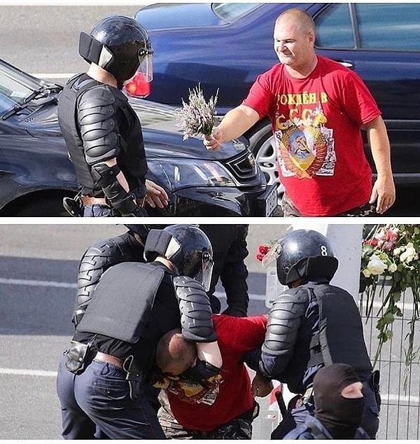 4. Belarus'ta bir protestocu polise çiçek uzatıyor.