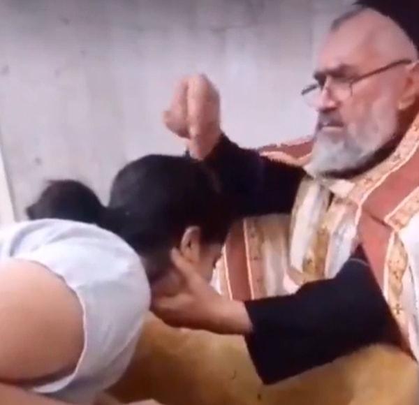 Sosyal medyada paylaşılan ancak nerede çekildiği hakkında bilgi verilmeyen görüntülerde bir papaz, kadını kutsal su ile kutsuyor.