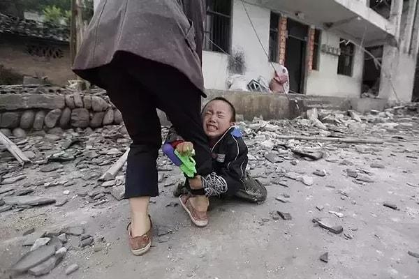 8. 6.6 şiddetindeki depremin ardından annesinin bacağına sarılarak ağlayan bir çocuk.
