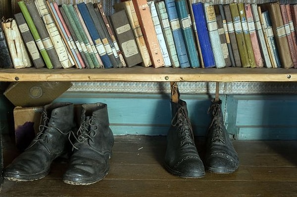 Его военные ботинки стоят под прикроватным книжным шкафом
