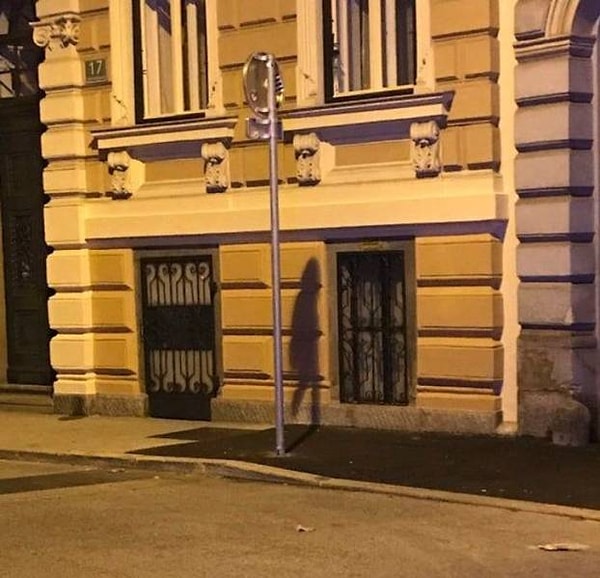 19. Тень от дорожного знака сложилась в ребенка, бредущего домой из школы в дождливый день.