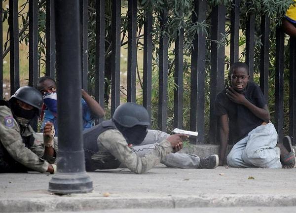 9. Haiti Ulusal Polislerinin Champ de Mars'ta silahlı bir suçluyu hedef alırken kameraya yansıyan çocuk.