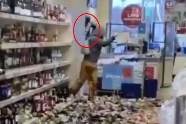 Kadın marketteki raflarda bulunan yüzlerce alkol şişesini yere atarak kırdı.