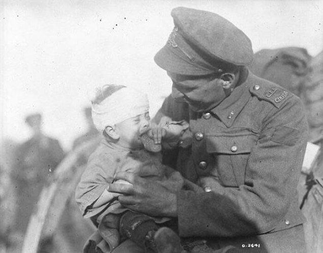 16. Birinci Dünya Savaşı sırasında Kanadalı bir asker, annesi öldürülen küçük Belçikalı bebeği sakinleştirmeye çalıyor. (1918)