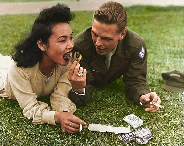 6. 11. Hava İndirme Tümeni'nden bir ABD askeri, Japonya'da yerel bir kızla biraz çikolata paylaşıyor (1946).