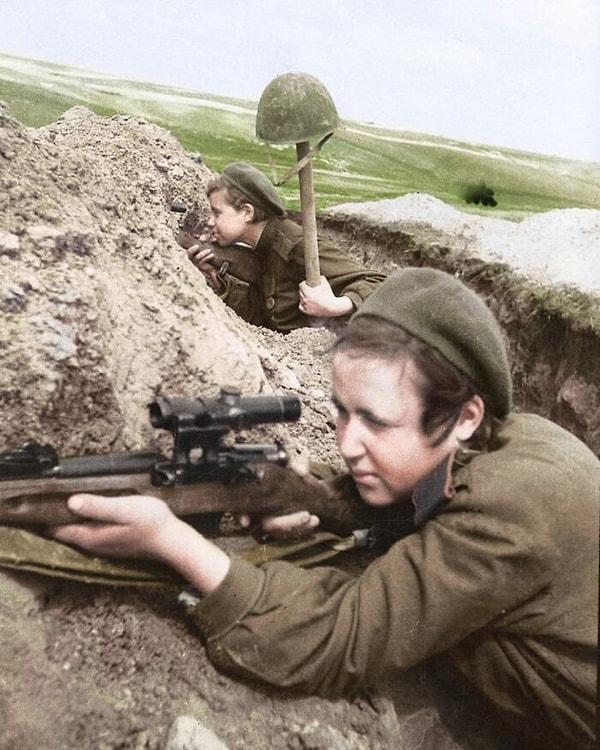 13. Doğu Cephesi'ndeki bir siperden ateş eden iki kadın Rus keskin nişancı (1943).
