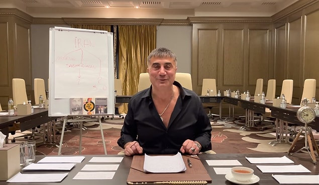 Yedinci videoda Sedat Peker'in arkasında bulunan ''İran, Mersin, Sabiha Gökçen'' şeması yazılmış tahta, ''Hazreti Ali İslam'ın Doğuşu ve İlk Ayrılıklar'' ,''Her Şey Seninle Başlar'', ''Ezilmiş ve Aşağılanmışlar'' kitapları ve masanın üstündeki saat göze çarpıyor.