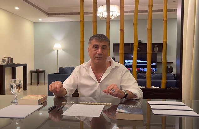 İlk videoda masada bulunan ''Omerta: Suskunluk Yasası'', ''Aptallar Erken Ölür'' kitapları ve üç zarf göze çarpıyor. Peker'in arkasında bulunan televizyonda ise TRT Haber'in ''MHP'nin Kurucu Lideri Alparslan Türkeş'in Vefatının 24. Yılı'' adlı belgeselinin açık olduğu görülüyor.