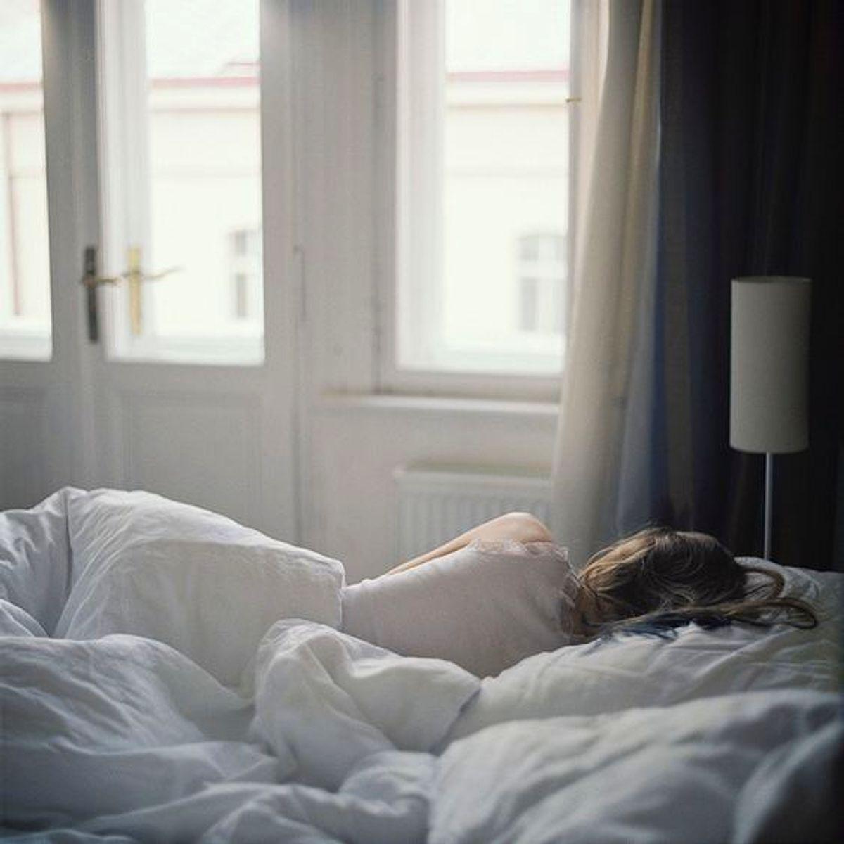 Девушка на кровати со спины.
