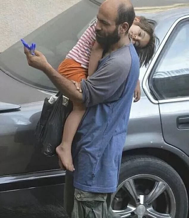1. Suriyeli mülteci olan Abdu, kızını kucağında tutarak kalem satıyor...