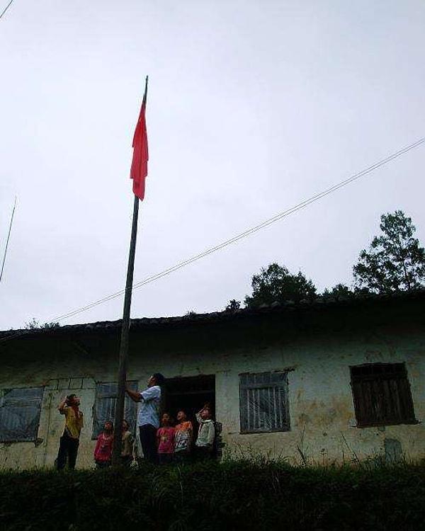 10. Yardıma muhtaç bölgelerde 12 yıl boyunca çalışan Çinli öğretmen Li Shunxiang ve 7 öğrencisi, yeni öğretim yılı için bayraklarını çekiyorlar.