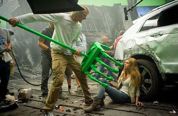 19. Yönetmen Micheal Bay, Transformers: Kayıp Çağ setinde oyuncu Nicola Anne Peltz'e onu yakalayacak olan transformers'ın elini gösteriyor.