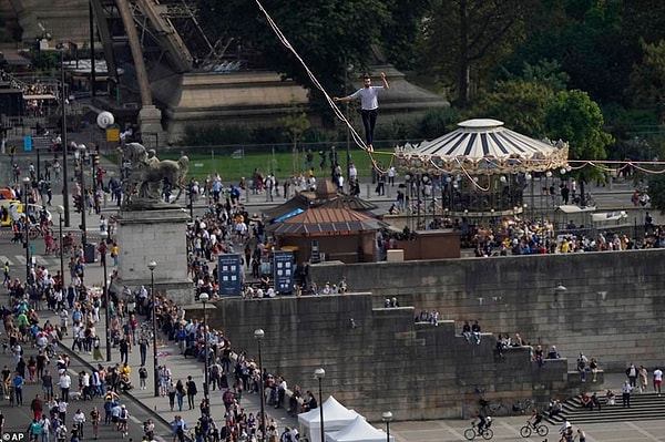 Французский канатоходец Натан Полен во второй раз выступает на 70-метровой высоте между Эйфелевой башней и театром Шайо через Сену.