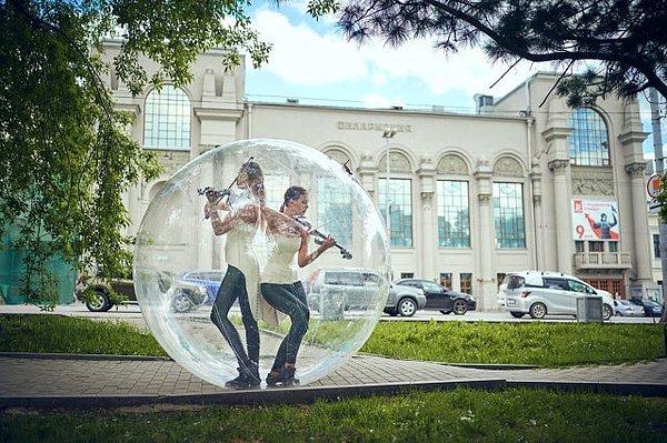 12. Koronavirüsten korunmak için devasa bir plastik balonun içinde keman çalan müzisyenler: