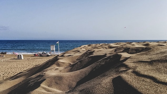 İspanya'nın Kanarya adasındaki Dunas de Maspalomas Özel Doğa Koruma Alanı, deniz kıyısındaki vahşi kum tepeleriyle tanınır ve adanın en ünlü turistik mekanlarından biridir.