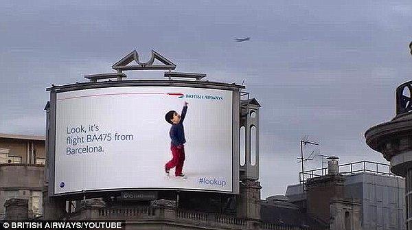 Tam bu sırada çocuğun gösterdiği yerde bir uçak görünecektir. Evet, bulutların arasından bir uçak geçerken reklam panosu ona göre gösterime başlayacaktır. Sonunda ise ekranda şu yazı belirecektir, "Bak, Barcelona’dan gelen BA475 sefer sayılı uçak."